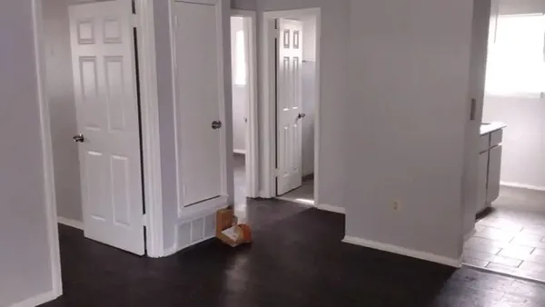 a view of a livingroom with wooden floor and a fan