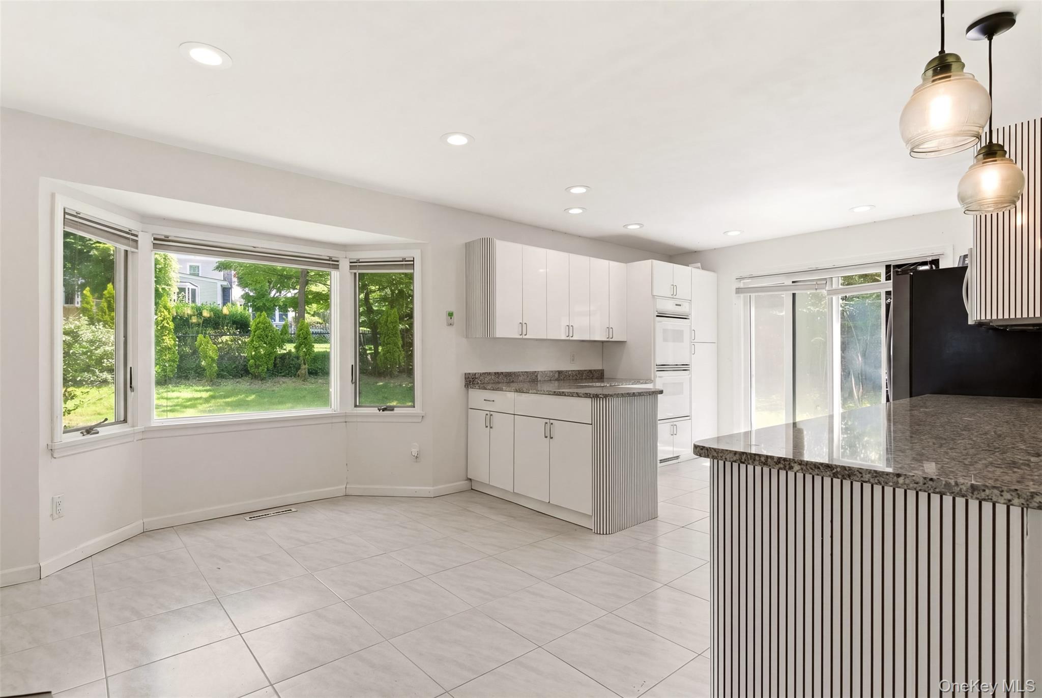 106 Vineyard Road Huntington, NY 11743 - Photo 17 of 25 a kitchen with a refrigerator and white cabinets