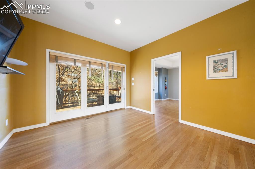220 Preservation Way Colorado Springs, CO 80919 - Photo 11 of 39 a view of an empty room with wooden floor and a window