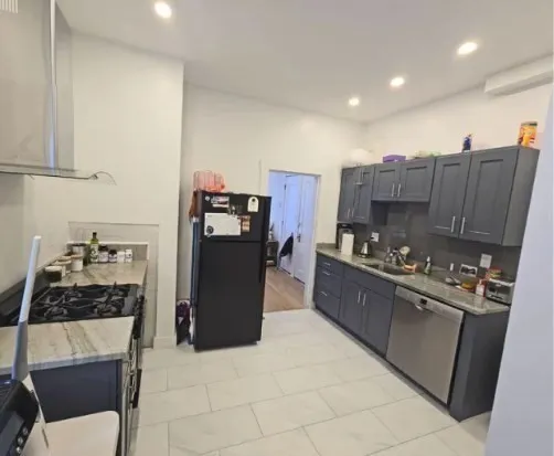 a kitchen with stainless steel appliances granite countertop a stove a sink a refrigerator and a cabinets