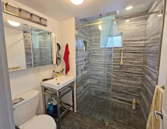 a bathroom with a sink toilet and shower