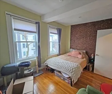 a bedroom with a bed and wooden floor