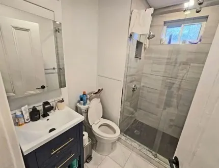 a bathroom with a sink a toilet a mirror and shower