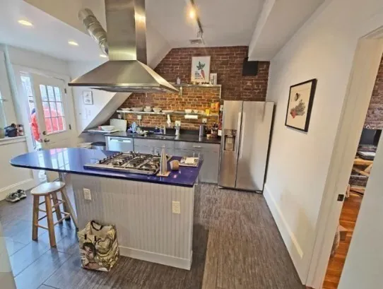 a kitchen with stainless steel appliances granite countertop a refrigerator a stove and a wooden floors