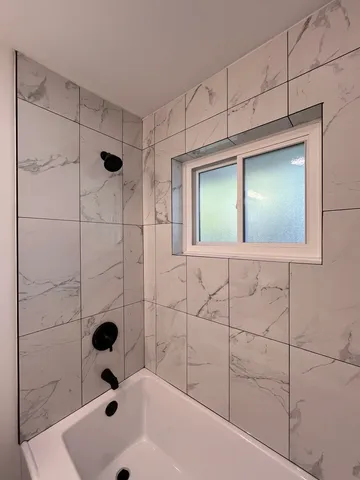 a bathroom with a tub and a shower