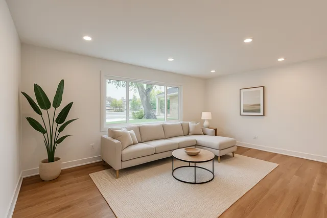 a living room with furniture a window and a potted plant