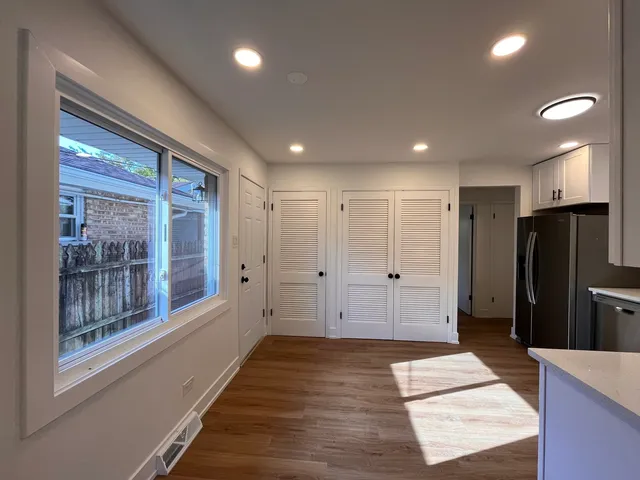 a view of a hallway with wooden floor and a cabinet