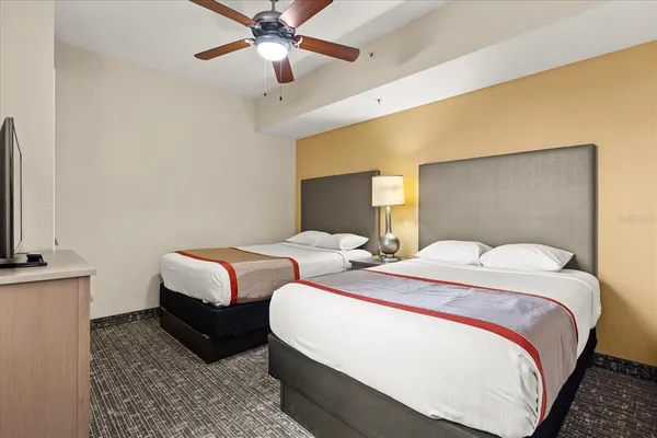 a bedroom with two beds and a flat screen tv