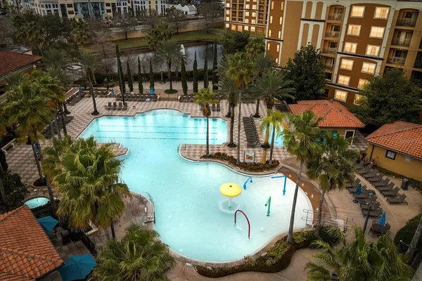 a view of a swimming pool with a patio and fire pit