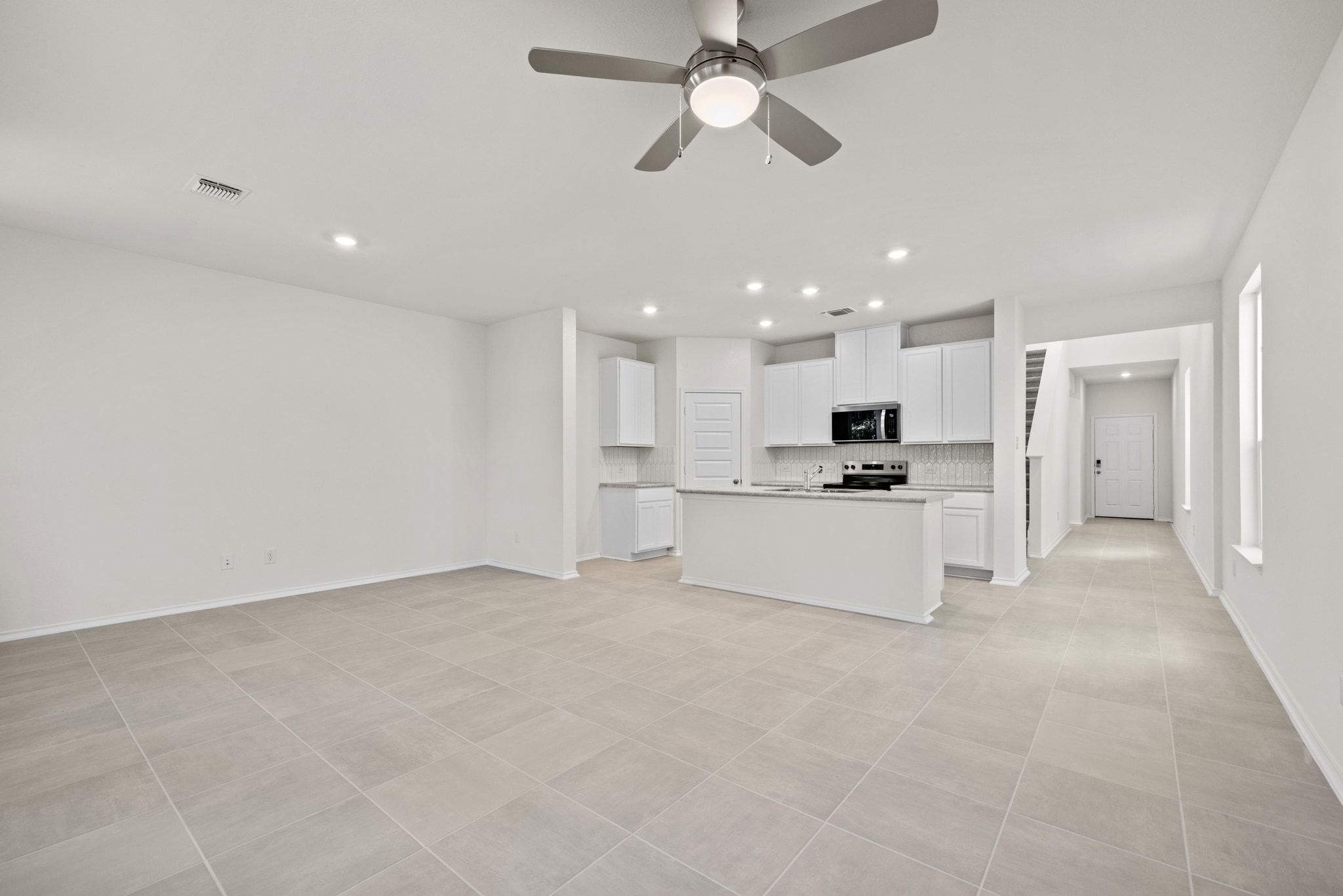 248 Feathers Street Jarrell, TX 76537 - Photo 5 of 32 a view of kitchen with kitchen island white cabinets and refrigerator