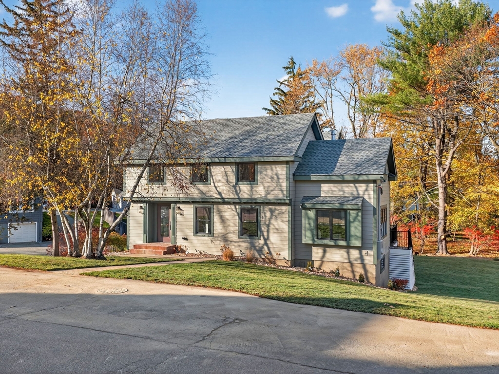 a front view of a house with a garden and trees