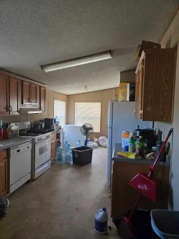 a kitchen filled with a white stove top oven and cabinets
