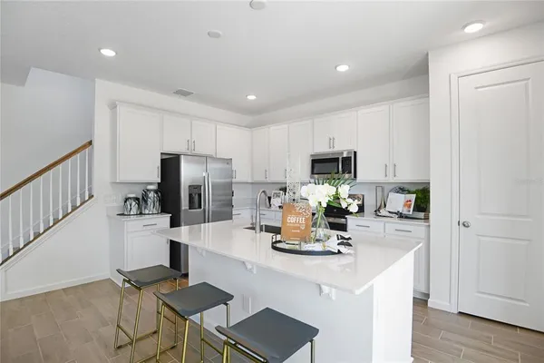 a kitchen with stainless steel appliances granite countertop a refrigerator and a stove top oven