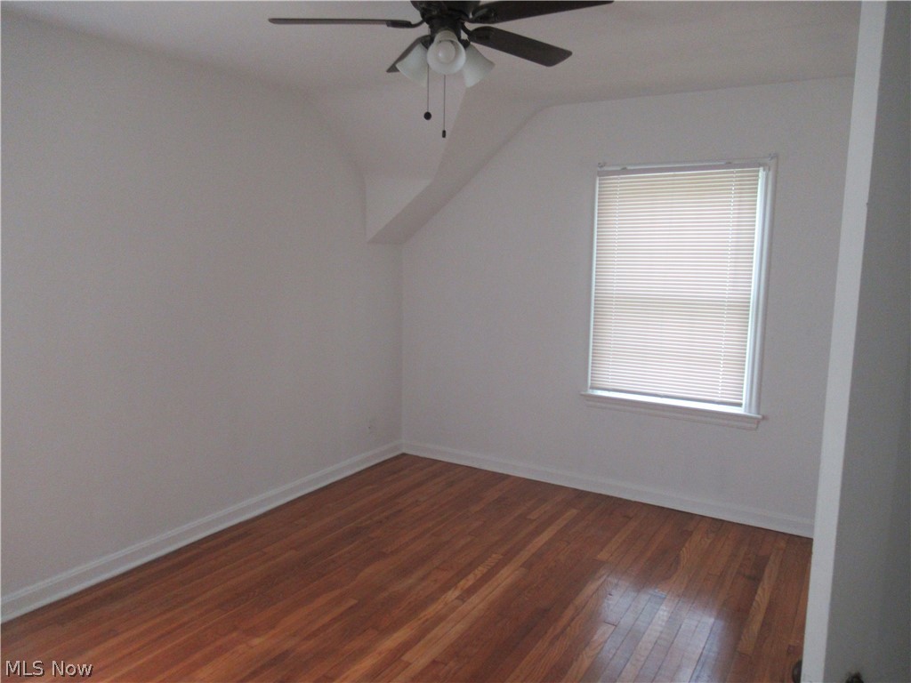 3824 East Antisdale Road Cleveland, OH 44118 - Photo 18 of 27 Room featuring wood-finish flooring, a white window frame with blinds, and an angled ceiling line