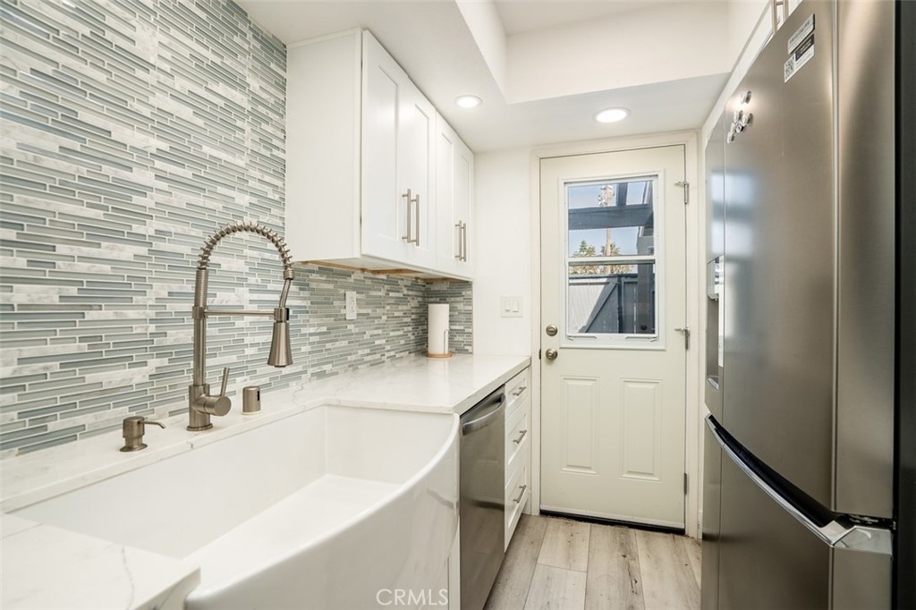 16734 Algonquin Street, Unit 6 Huntington Beach, CA 92649 - Photo 11 of 27 a kitchen with a sink cabinets and wooden floor
