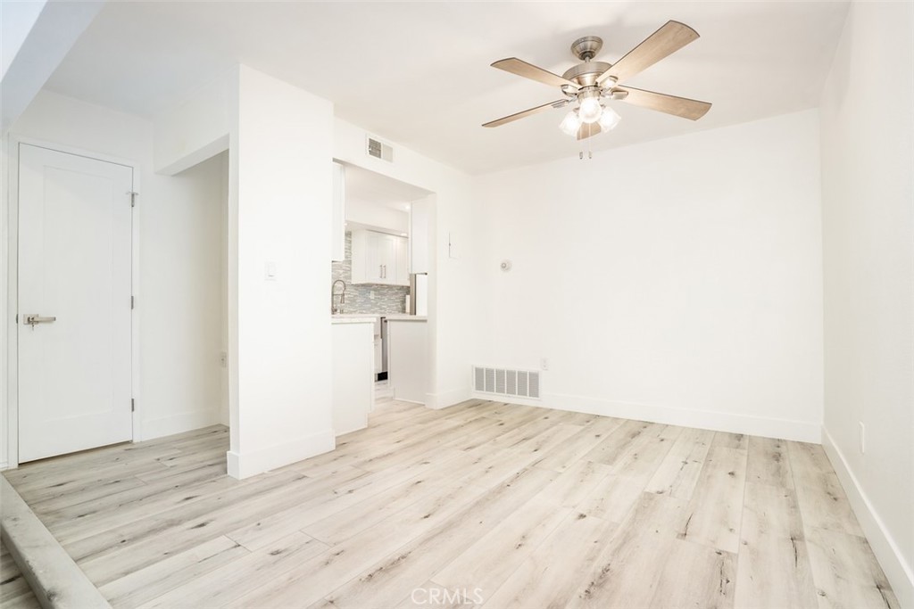 16734 Algonquin Street, Unit 6 Huntington Beach, CA 92649 - Photo 8 of 27 a view of kitchen and empty room with wooden floor