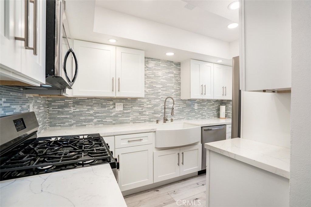 16734 Algonquin Street, Unit 6 Huntington Beach, CA 92649 - Photo 9 of 27 a kitchen with a sink stove and cabinets