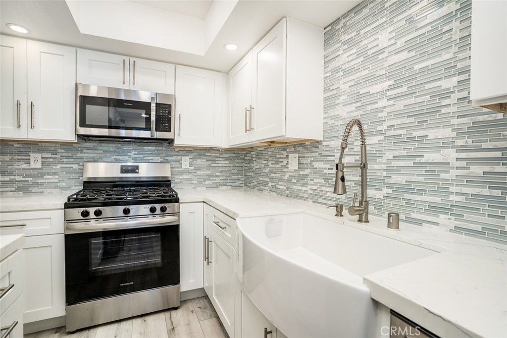 16734 Algonquin Street, Unit 6 Huntington Beach, CA 92649 - Photo 10 of 27 a kitchen with stainless steel appliances a stove a sink and a microwave
