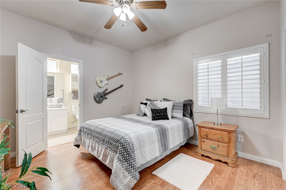 1604 Cattle Ranch Place Henderson, NV 89002 - Photo 49 of 99 Hardwood floors and a ceiling fan enhance this inviting bedroom, featuring a bright window with shutters.