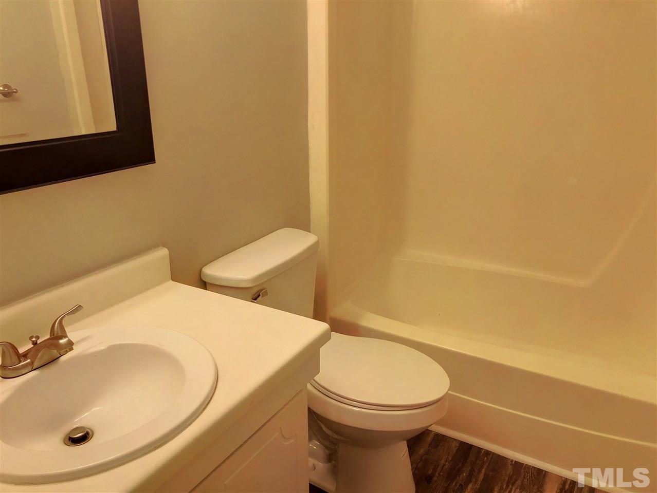 5086 Flint Ridge Place, Unit 5086 Raleigh, NC 27609 - Photo 6 of 8 a bathroom with a sink a toilet and mirror