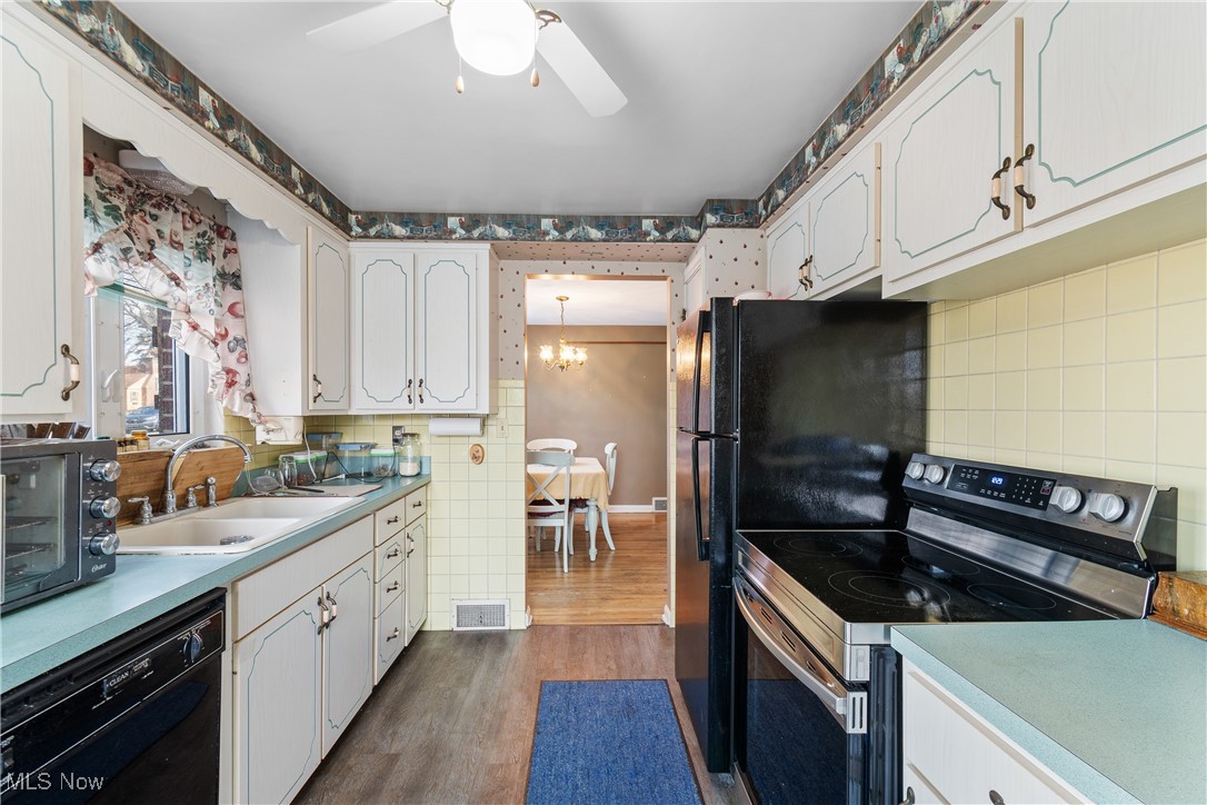 1527 Ridge Road Northwest Canton, OH 44703 - Photo 11 of 27 Kitchen featuring white cabinetry, sink, stainless steel electric range, and dishwasher