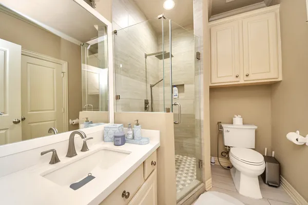 a bathroom with a sink a toilet and shower