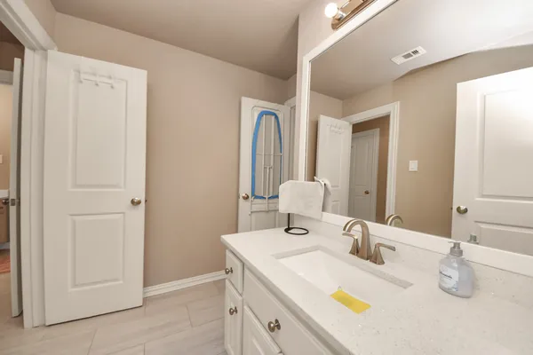 a en suite bathroom with a shower sink and mirror