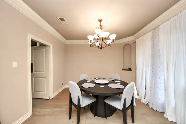 a view of a dining room with a table and chairs
