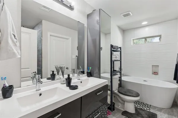 a bathroom with a double vanity sink toilet and shower