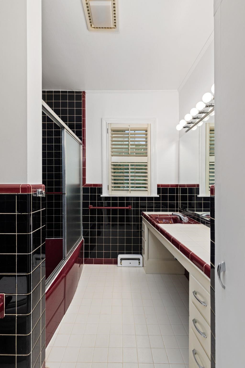 1906 Willow Road Corinth, MS 38834 - Photo 22 of 40 a bathroom with a double vanity sink a large mirror and a bathtub