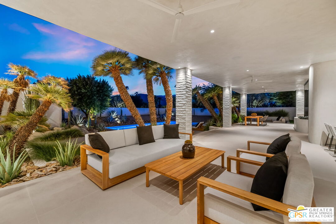 71000 Tamarisk Lane Rancho Mirage, CA 92270 - Photo 26 of 58 a living room with furniture a flat screen tv and a floor to ceiling window
