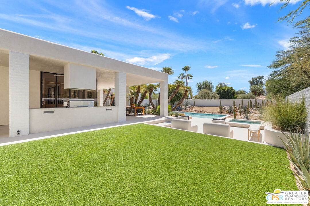 71000 Tamarisk Lane Rancho Mirage, CA 92270 - Photo 31 of 58 a view of a patio with dining table and chairs with plants and wooden fence