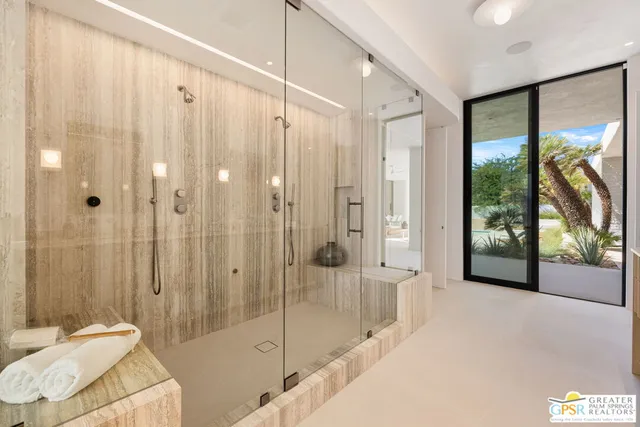 a bedroom with a large bed and a flat tv screen on dresser