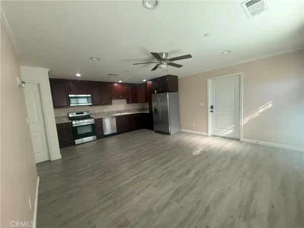 a view of kitchen with stainless steel appliances refrigerator stove microwave and cabinets