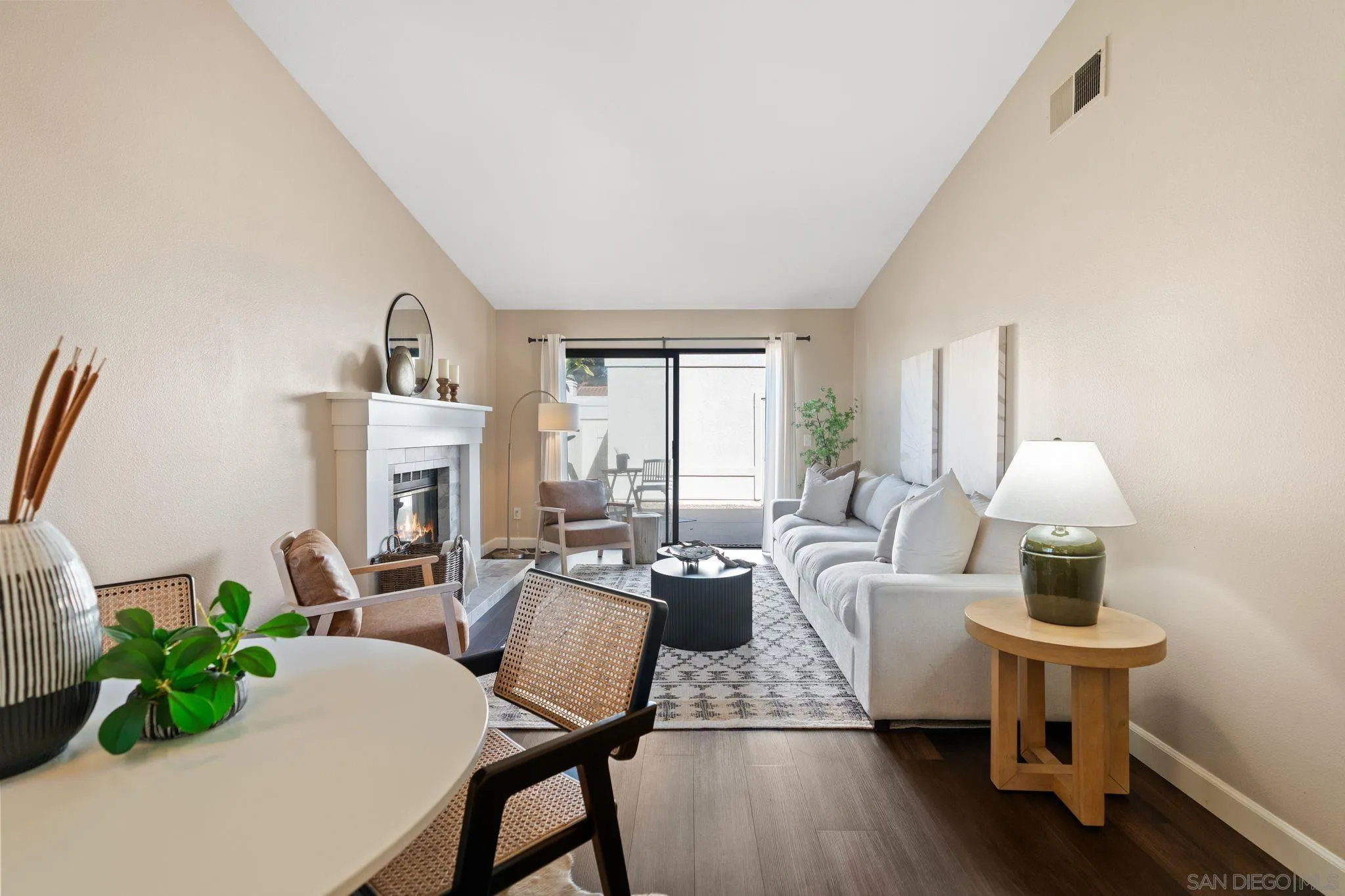 6922 Pear Tree Drive Carlsbad, CA 92011 - Photo 12 of 44 a living room with furniture a fireplace and a potted plant