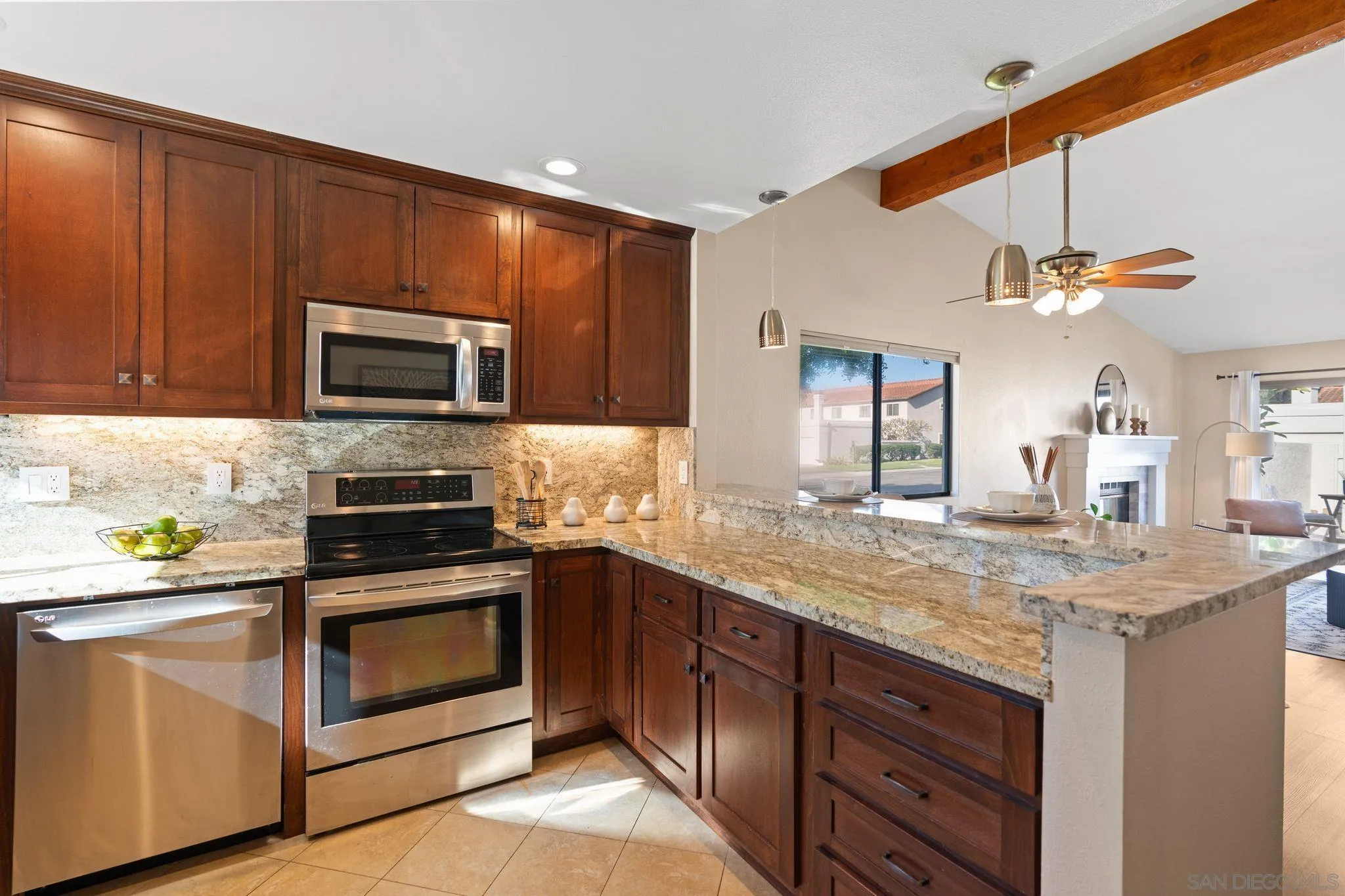 6922 Pear Tree Drive Carlsbad, CA 92011 - Photo 15 of 44 a kitchen with stainless steel appliances granite countertop a stove a sink and a microwave