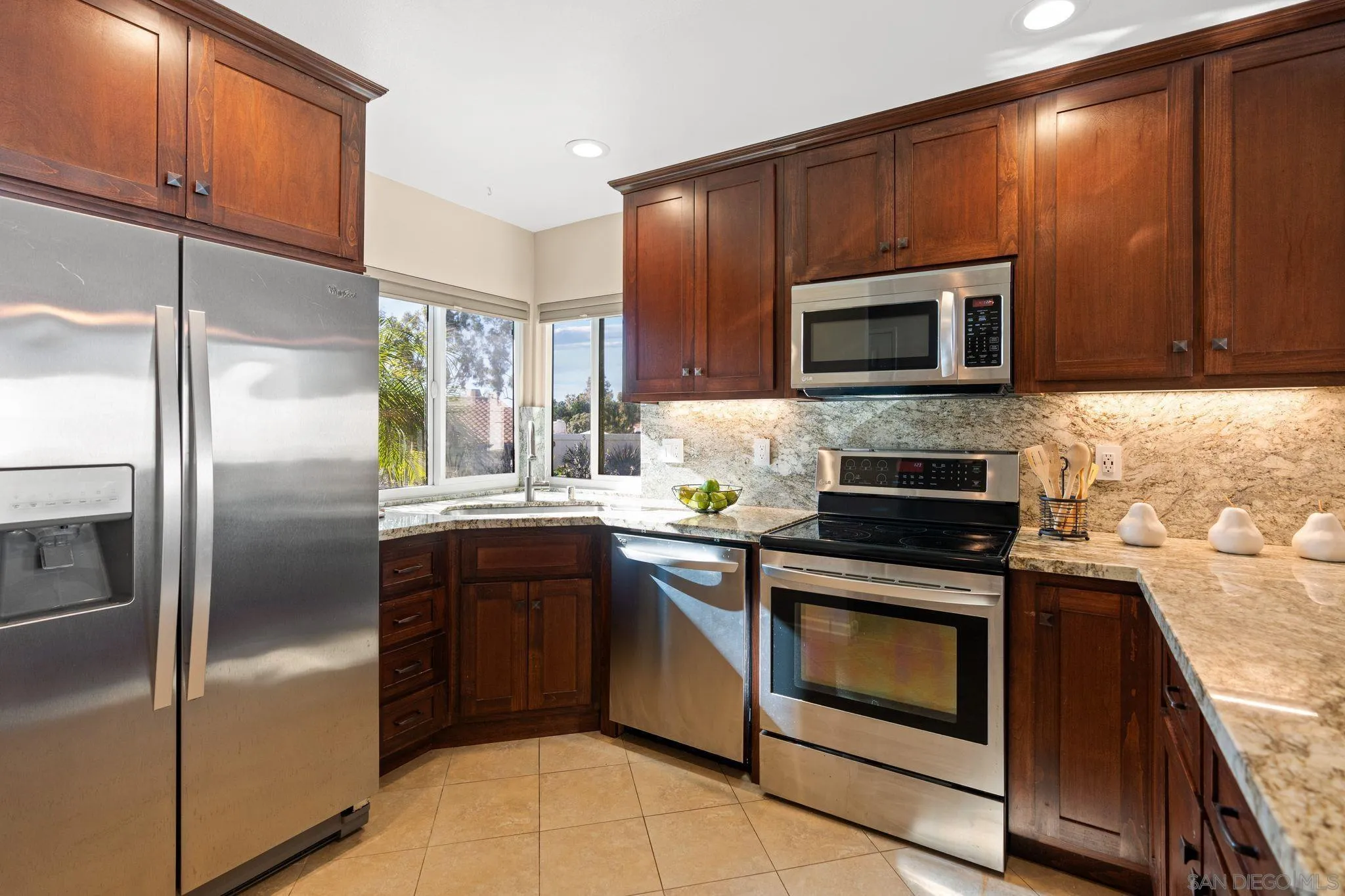 6922 Pear Tree Drive Carlsbad, CA 92011 - Photo 19 of 44 a kitchen with stainless steel appliances granite countertop a stove a refrigerator and a microwave