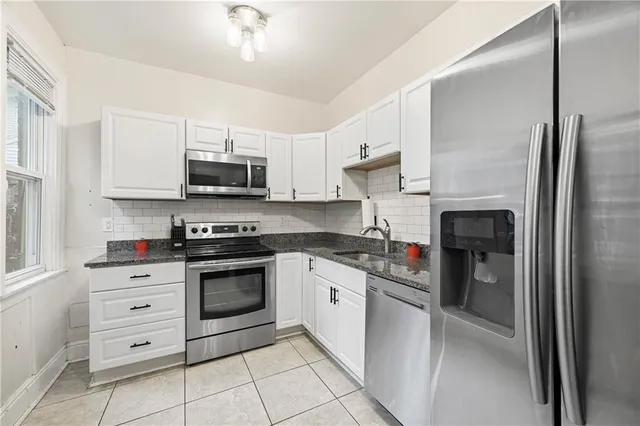 a kitchen with stainless steel appliances granite countertop a refrigerator and a stove