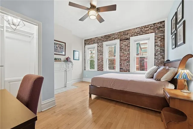 a spacious bedroom with a bed and wooden floor