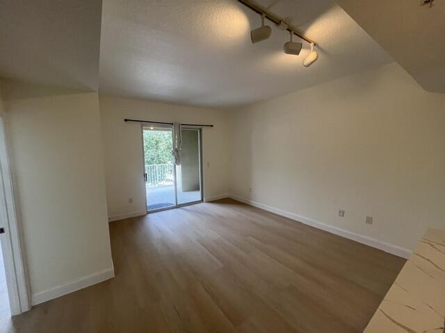1155 Main Street, Unit 209 Jupiter, FL 33458 - Photo 7 of 10 an empty room with wooden floor and windows
