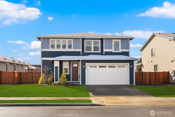 a view of a house with a yard and a garage
