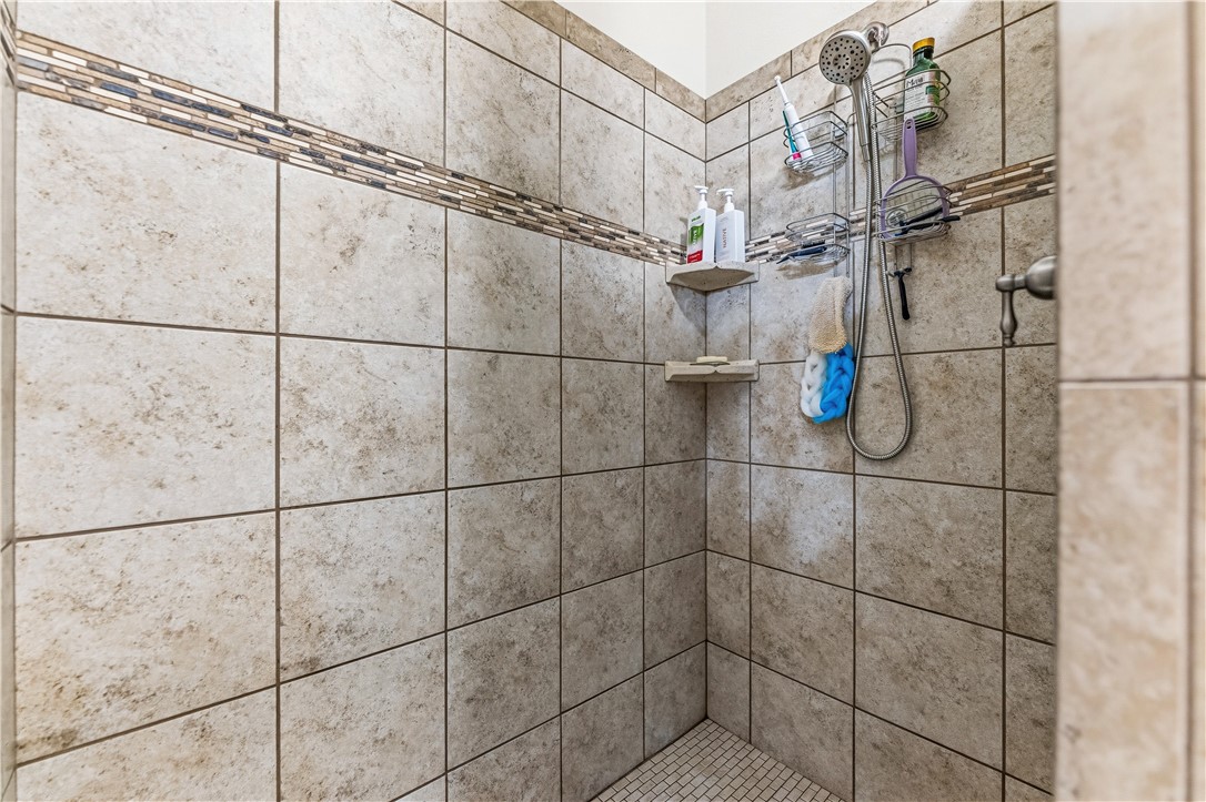4143 North Stampede Road Kingman, AZ 86401 - Photo 22 of 42 Tiled shower enclosure featuring a decorative mosaic accent band