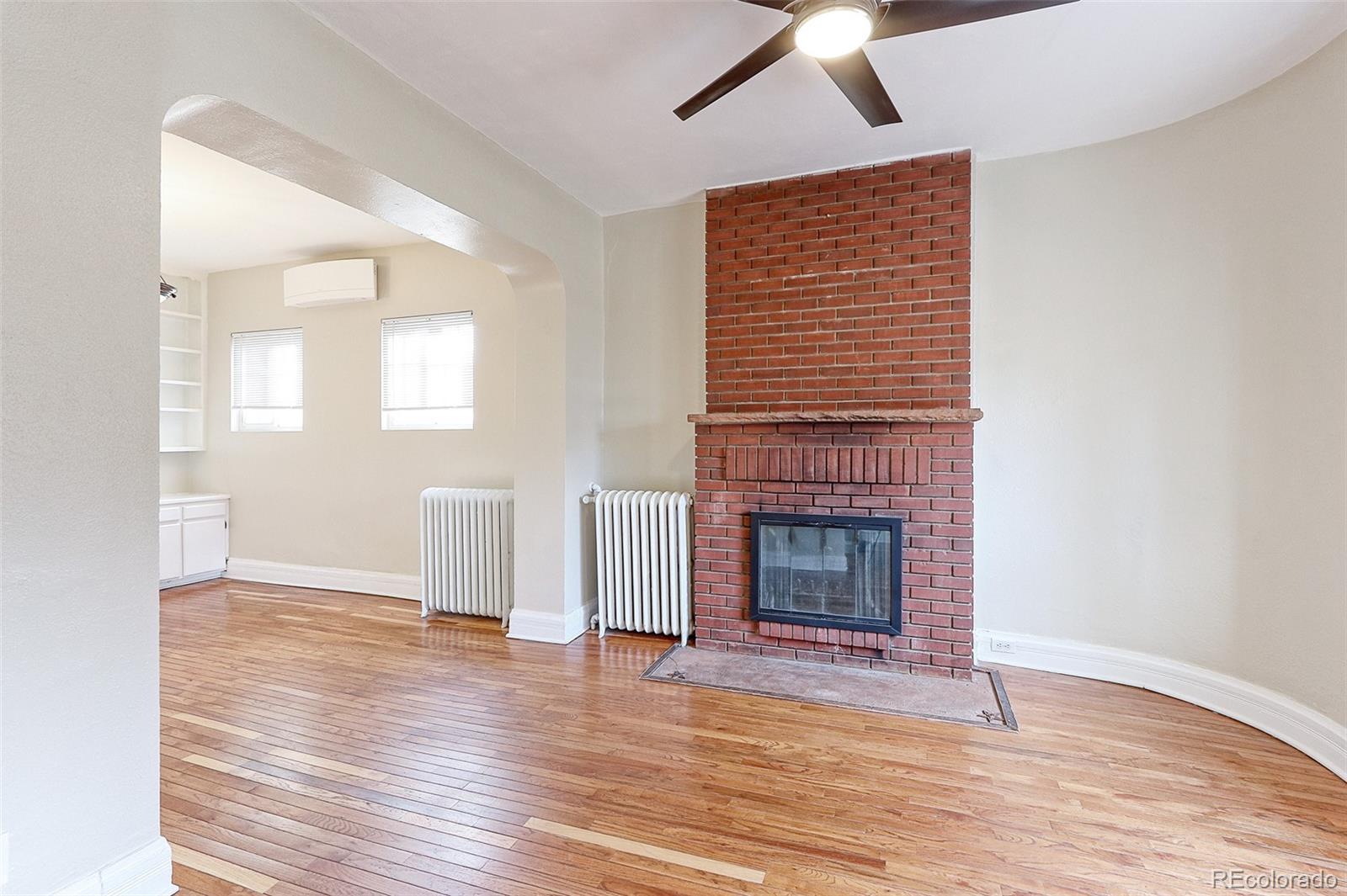 4574 Stuart Street Denver, CO 80212 - Photo 11 of 43 an empty room with wooden floor fireplace and windows