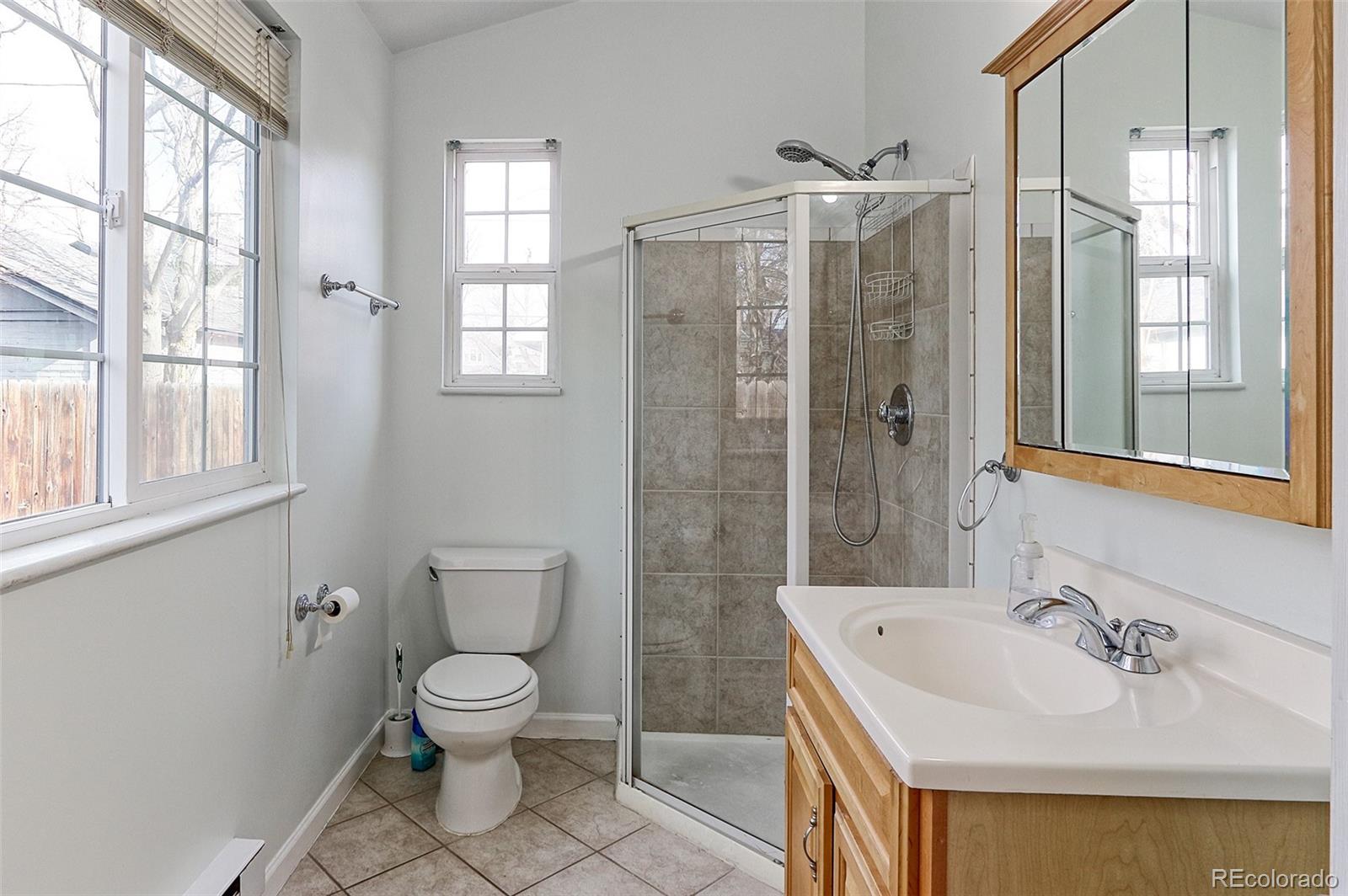 4574 Stuart Street Denver, CO 80212 - Photo 16 of 43 a bathroom with a sink toilet and shower