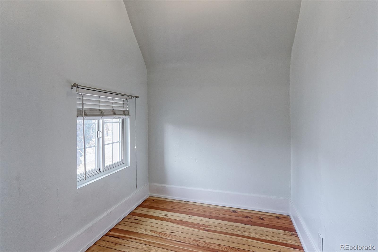 4574 Stuart Street Denver, CO 80212 - Photo 26 of 43 a view of an empty room with wooden floor and a window