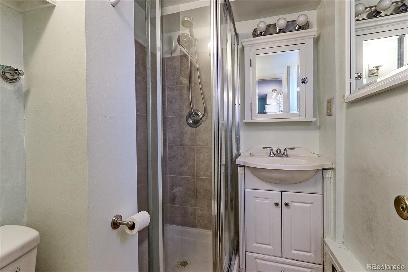 4574 Stuart Street Denver, CO 80212 - Photo 36 of 43 a bathroom with a granite countertop sink toilet and shower
