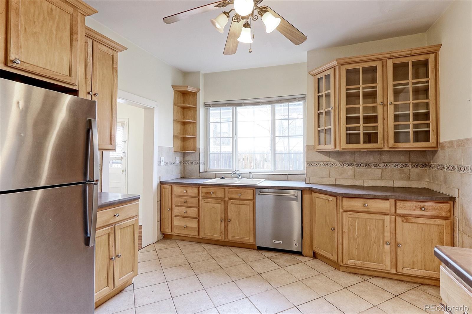 4574 Stuart Street Denver, CO 80212 - Photo 6 of 43 a kitchen with white cabinets window and refrigerator