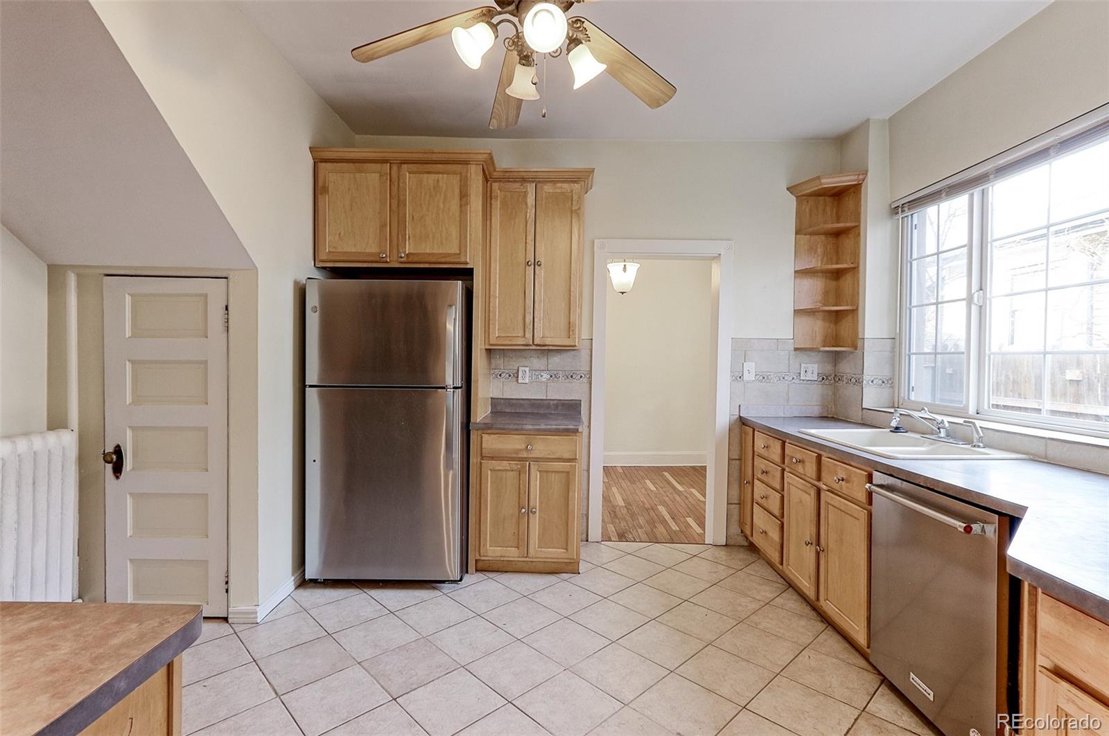 4574 Stuart Street Denver, CO 80212 - Photo 8 of 43 a kitchen with stainless steel appliances granite countertop a refrigerator and a sink