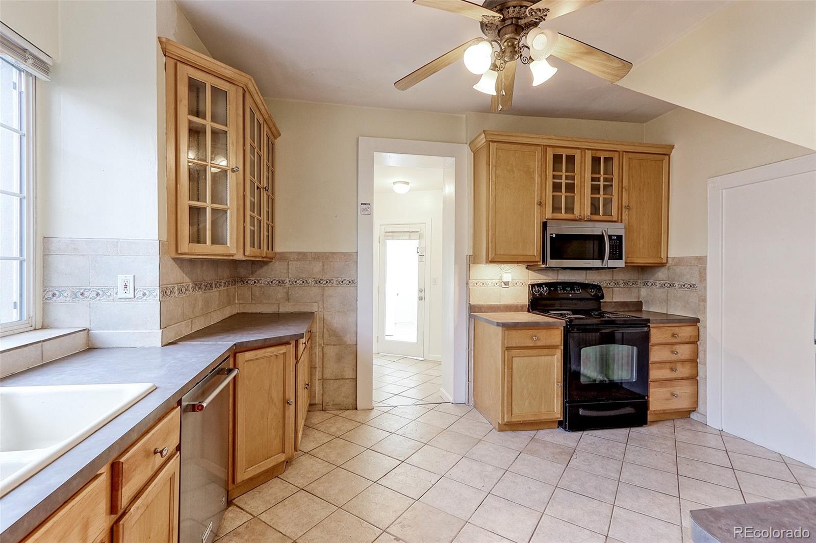 4574 Stuart Street Denver, CO 80212 - Photo 9 of 43 a kitchen with stainless steel appliances granite countertop a stove and a sink