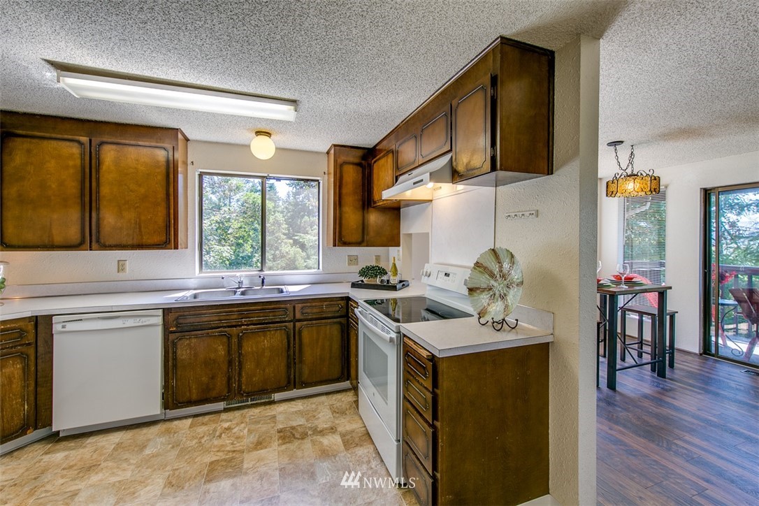 705 Sheridan Road Bremerton, WA 98310 - Photo 7 of 25 a kitchen with a sink stove and wooden cabinets